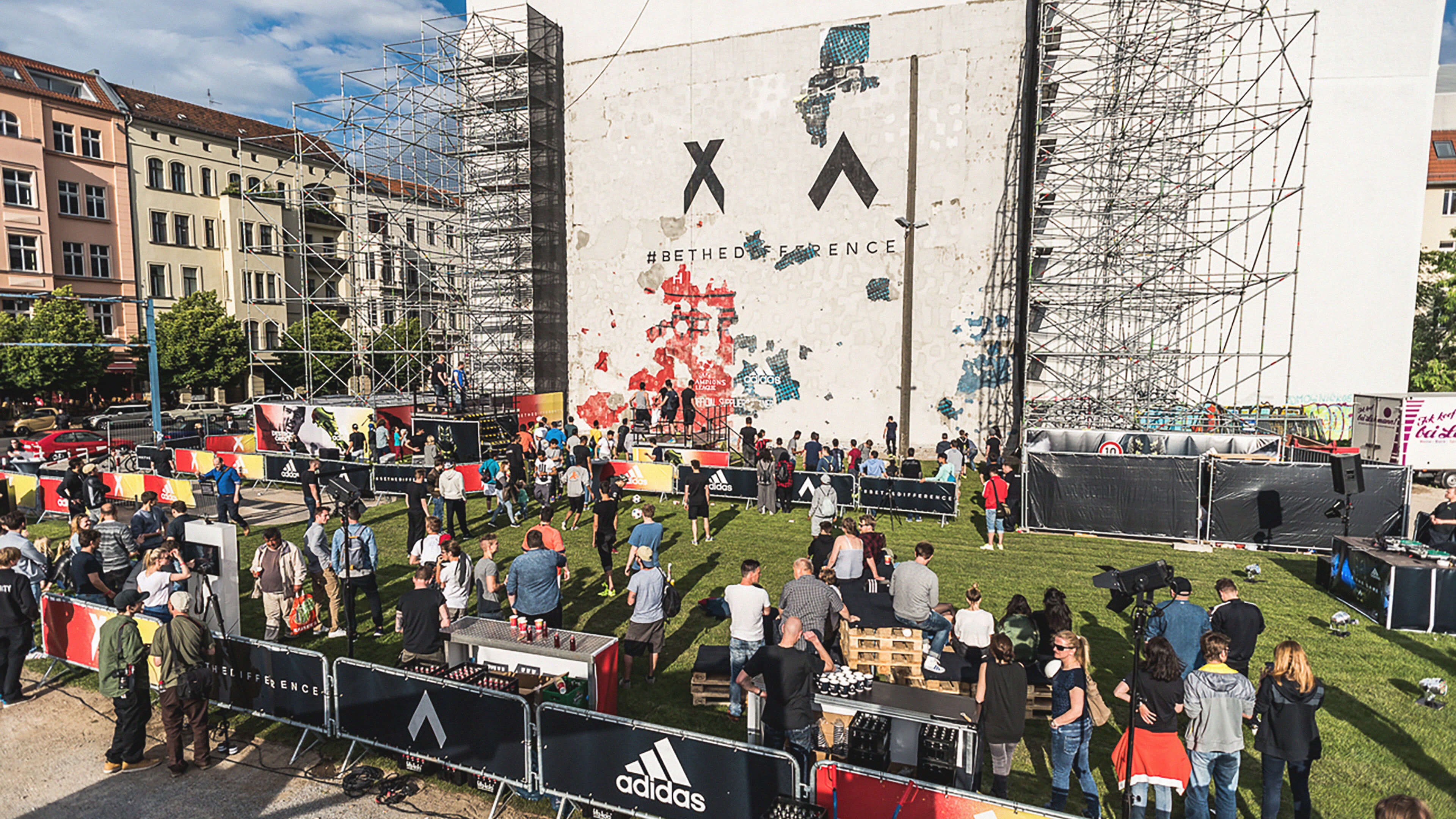 Menschenmenge steht vor der Mauer und beobachtet das abbröckeln des Putzes