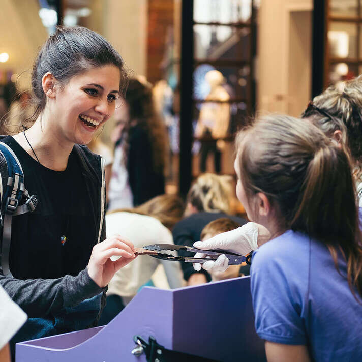 Eine Mitarbeiterin von Milka verteilt Schokolade an die Besucher
